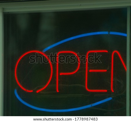 Neon Open sign in red and blue with red letters and blue circle