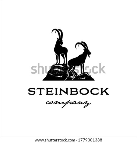 Two steinbock standing on a rock cliff with a classic design Royalty-Free Stock Photo #1779001388