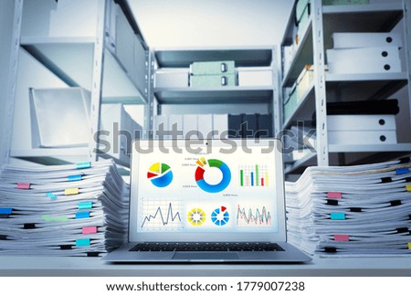 Modern laptop and documents on desk in office. Business analytics