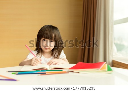 Little girl drawing picture at home