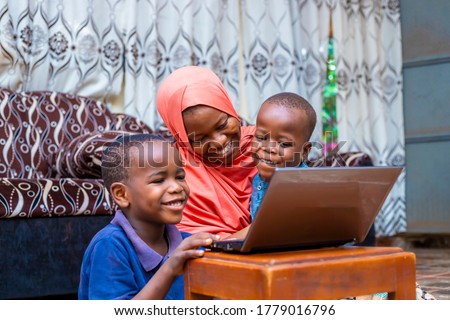 black african single mother with two little preschool sons sitting using computer watching cartoon,online surfing internet