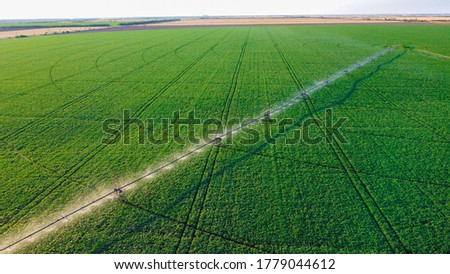 farming irrigation sprinklers system on cultivated agricultural landscape field. aerial view Royalty-Free Stock Photo #1779044612