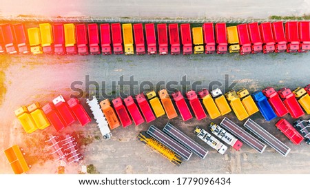 Aerial view of colorful dump trucks, trailers, trucks and chassis in the Parking lot for new cars. Factory for the production of heavy-duty vehicles. Top view. Reverse illumination.  Royalty-Free Stock Photo #1779096434