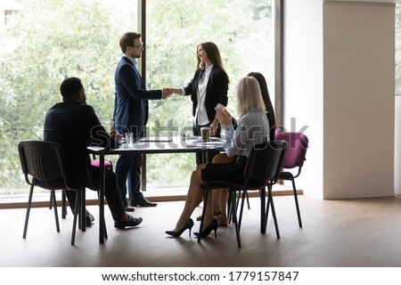 Boss express gratitude shake hands female business coach after seminar corporate training, diverse staff clap hands showing respect. Promoted employee, career advance, loyalty and appreciation concept Royalty-Free Stock Photo #1779157847