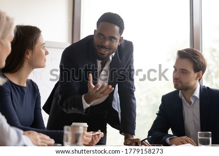 African mentor gives valuable advice to staff members during workshop training. Diverse workmates brainstorming share ideas and creative thoughts, team listen leader of project during meeting concept Royalty-Free Stock Photo #1779158273