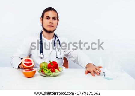 young pretty doctor with stethoscope holding fruits, healthy food care concept