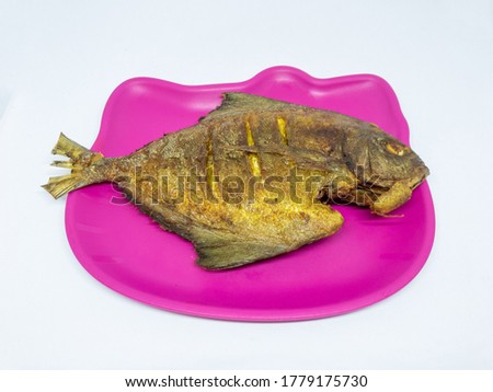 Fried fish on a pink plate isolated on a white background