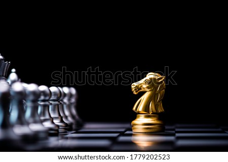 Golden horse chess encounters with silver chess enemy on chess board and black background. Market or business competitor concept. Royalty-Free Stock Photo #1779202523