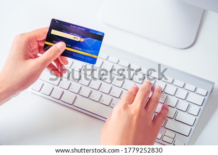 Technology business concoept: One hand hold a Credit card while the other typing a security code on white keyboard and white table Royalty-Free Stock Photo #1779252830