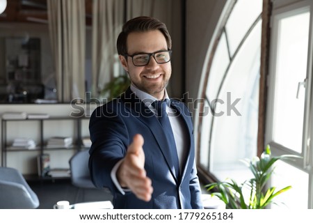 Portrait of smiling young Caucasian male boss or director in formal suit stretch hand greeting get acquainted with client, happy businessman meet welcome new employee, recruitment concept Royalty-Free Stock Photo #1779265184
