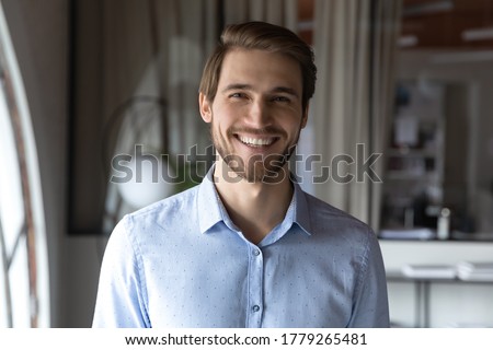 Close up headshot portrait of smiling caucasian businessman look at camera posing in office, profile picture of happy positive male employee show confidence and leadership, employment concept