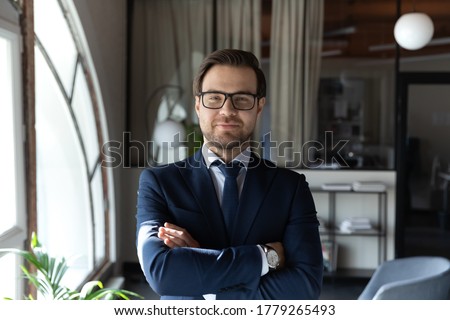 Profile picture of confident young caucasian businessman in formal suit and glasses posing in office, portrait of successful male boss or director show confidence and leadership, recruitment concept