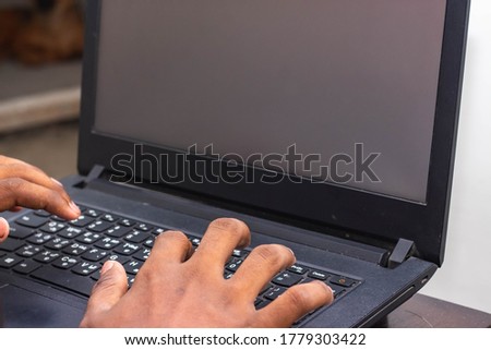 Work from Home - Man's hands using laptop with screen on desk in home interior. Mockup style image of a hand using and touching laptop on table at home. WFH Due to covid 19 pandemic situation.