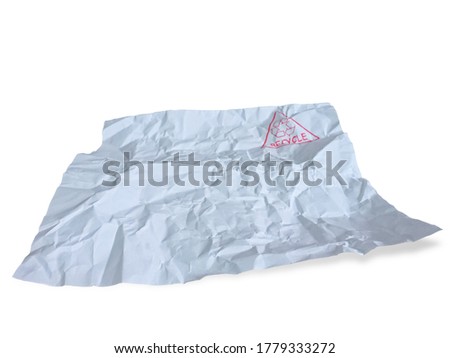 Red recycle symbol stamp on a white wrinkled waste paper isolated on white background with shadow and clipping path.