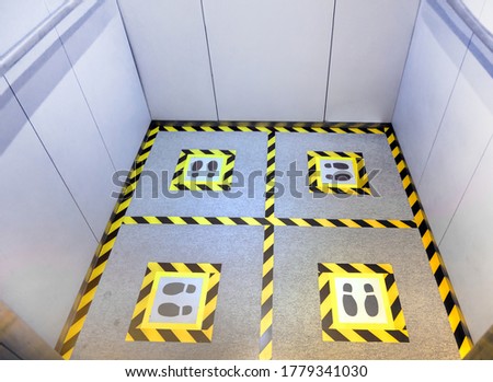 making social dostance on elevator floor with marker tape and foot print symbol in coronavirus pandemic