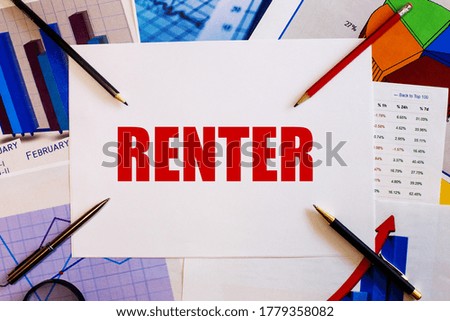 The word RENTER is written on a white table near graphs, pencils and pens. Financial concept