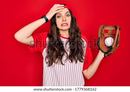 Young beautiful sportswoman with blue eyes playing baseball using glove and ball stressed with hand on head, shocked with shame and surprise face, angry and frustrated. Fear and upset for mistake.