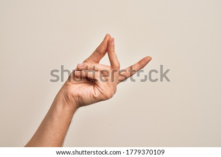 Hand of caucasian young man showing fingers over isolated white background snapping fingers for success, easy and click symbol gesture with hand Royalty-Free Stock Photo #1779370109