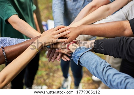 close-up photo of diverse people's hands gathered together, african american and caucasian people as one union. various ethnicities are friends all over the world Royalty-Free Stock Photo #1779385112