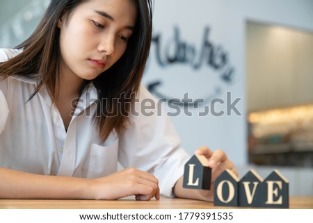 Asian young woman relaxation and enjoy a jigsaw on the table in words "Love" in cafe. Lifestyle women in the city concept.
