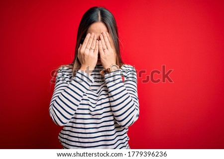 Young beautiful blonde woman with blue eyes wearing glasses standing over red background rubbing eyes for fatigue and headache, sleepy and tired expression. Vision problem