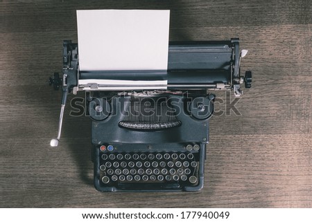 Top view of an old typewriter on a wooden table, photo in retro style