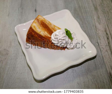 A slice of cheesecake topped with caramel and cinnamon sugar.
