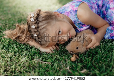 Stock Photo - Girl is holding a cute little rabbit, outdoor shoot