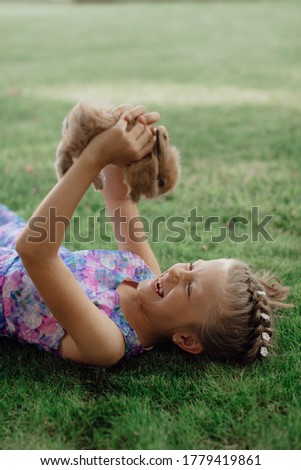 Stock Photo - Girl is holding a cute little rabbit, outdoor shoot