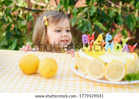 Birthday cake with happy birthday candles. Lemonade birthday party at summer park. food, celebration and festive concept. Little child drinks natural lemonade at stand in park