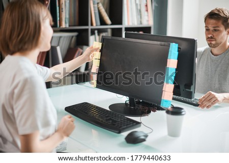 Team of professional programmers guy and girl working at a computer with an empty screen