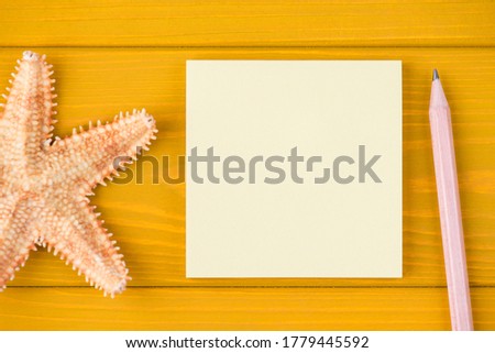 Top above overhead view close-up cropped photo of starfish blank note and pencil isolated on yellow wooden background with copyspace