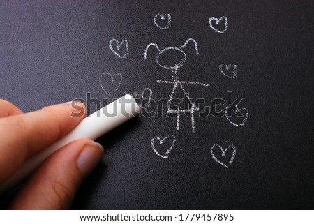 Chalk drawing woman with hearts on the blackboard