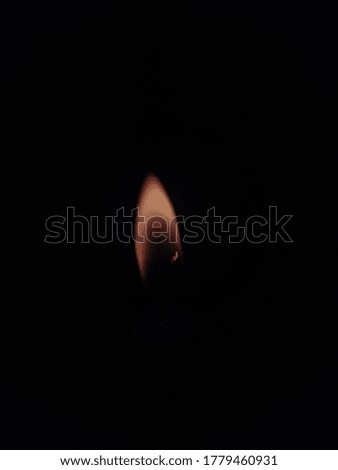 Candle flame in the black background.Burning candle isolated dark background. 