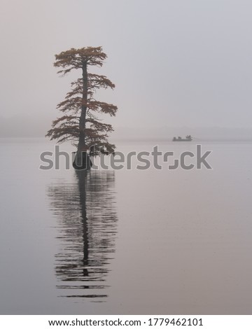 Fishing on Reelfoot lake in Tennessee during early morning fog in fall