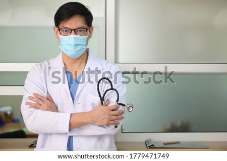 Coronavirus mask doctor wearing face protective mask against corona virus banner panoramic medical professional preventive gear.
and he hold stethoscope with hospital background Royalty-Free Stock Photo #1779471749