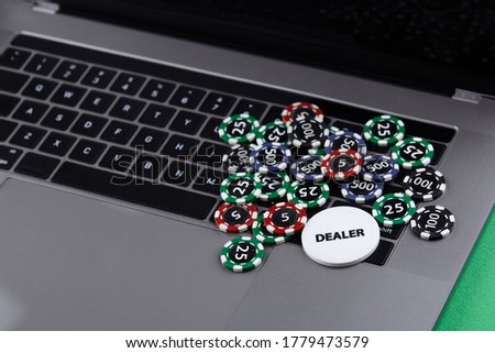 Different of cost casino chips stacking on a laptop. Dealer. Bet at game and win