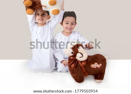 Little Muslim kids playing with sheep toys - celebrating Eid Al Adha - Happy Sacrifice Feast Royalty-Free Stock Photo #1779503954