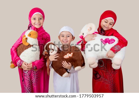 Little Muslim kids playing with sheep toys - celebrating Eid Al Adha - Happy Sacrifice Feast Royalty-Free Stock Photo #1779503957