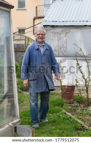 Happy elder man working in her garden, digging garden spring time. gardening concept.