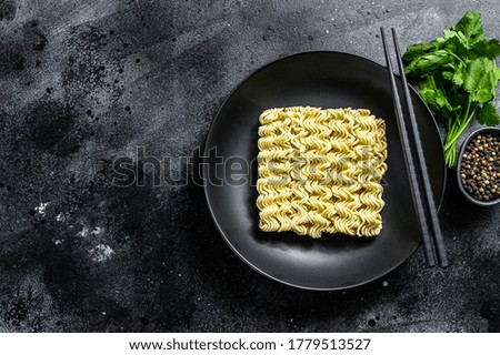 Dry, raw quick cooking noodle, instant noodles. Black background. Top view. Copy space