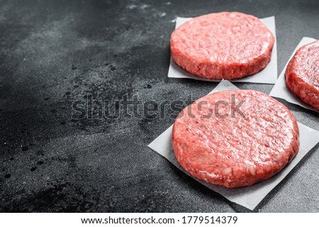Raw Burger patties, ground beef meat. Black background. Top view. Copy space