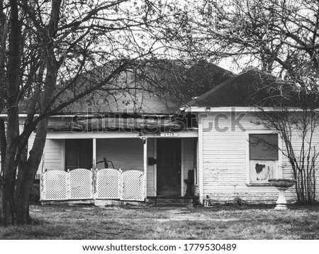 Black and white photo of dilapidated house.  