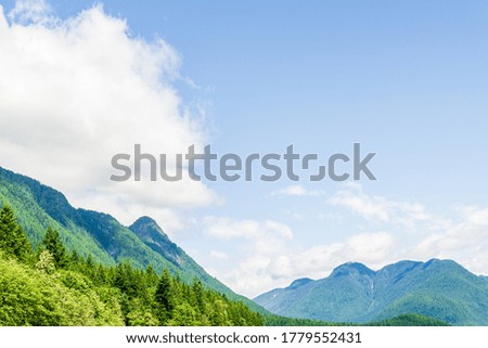 mountains covered with green forest blue sky with white clouds