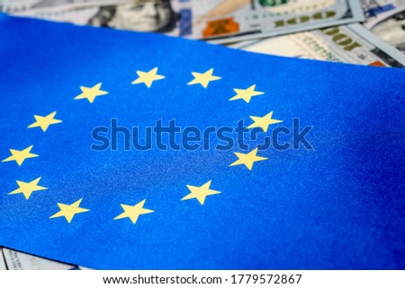 European Union flag with US dollars as background. Concept for investors, soft focus