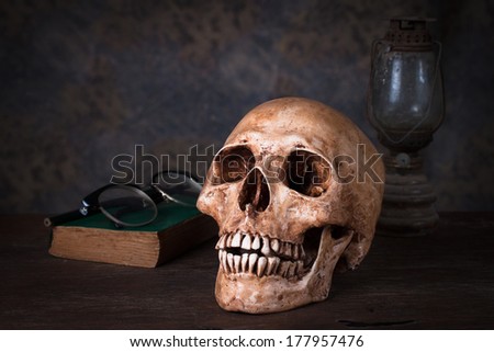 Group of objects on wood table. old book, human skull ,old rusty kerosene lamp, Still life