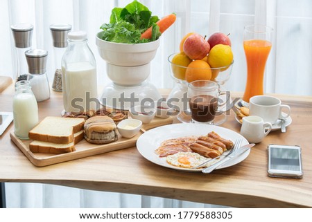 The continental breakfast table with black coffee, milk, bread , salad, fruit and juice. The chili sauce and ketchup to enhance the flavor. 