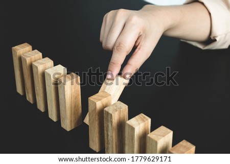 Hands of businesswomen playing wooden block game. Concept Risk of management and strategy plans for business growth and success.