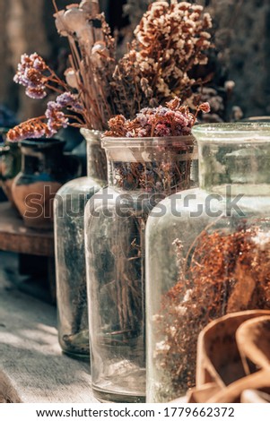 Closeup of a bouquet of dried flowers in vintage glass vase. Retro bouquet with poppy flowers