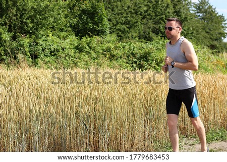 attractive man running near rye field and wearing sport dress